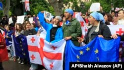 Manifestantes asisten a una protesta de la oposición contra "la ley rusa" cerca del edificio del Parlamento en el centro de Tbilisi, Georgia, el martes 14 de mayo de 2024. (Foto AP/Shakh Aivazov)