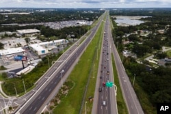 En esta imagen tomada con un dron, el tráfico fluye hacia el este por la carretera interestatal 4 mientras los residentes siguen las órdenes de evacuación ante el huracán Milton, el martes 8 de octubre de 2024, en Tampa, Florida. (Foto AP/Julio Cortez)